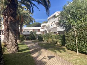 a palm tree in front of a building at Sol-y-Days Cyprianes appartement moderne avec piscine in La Grande-Motte