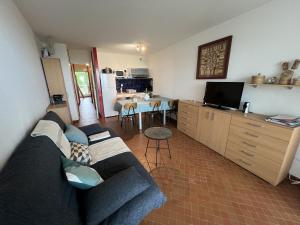 a living room with a couch and a kitchen at Sol-y-Days Belles Plages, front de mer avec piscine in La Grande Motte