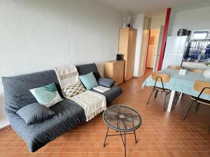 a living room with a couch and a table at Sol-y-Days Belles Plages, front de mer avec piscine in La Grande Motte