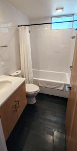 a bathroom with a toilet and a tub and a sink at Chic Townhome Haven rooted Downtown in Albuquerque +21 photos