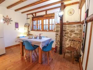 a dining room with a table and blue chairs at Tawny Owl Barn in Craven Arms