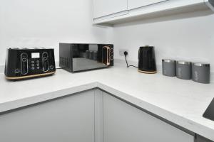 a kitchen counter with two microwaves and a microwave at Townhouse @ Eastwood Place Stoke in Etruria