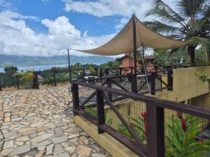 a fence with a tent on top of a house at Residencial Azul Marinho - Suítes por temporada in Ilhabela