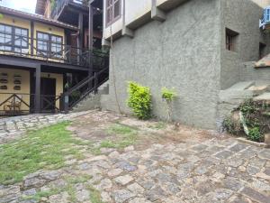 a stone walkway next to a building at Residencial Azul Marinho - Suítes por temporada in Ilhabela +37 photos