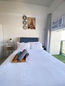 a bedroom with a white bed with two clocks on the wall at Twilight23 Condo in Cebu City +28 photos