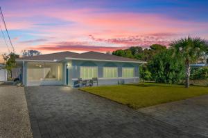 a house with a palm tree in the yard at Blue Tide Hideaway - Golf Cart, Sznl Hot Tub, Pets OK, FREE Daily Activities, & More! in Panama City