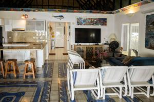 a living room with white chairs and a kitchen at Isla Amor in Cartagena de Indias