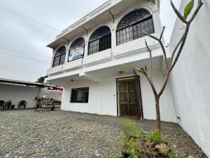 a white building with a tree in front of it at Las Casitas - Playas in Playas