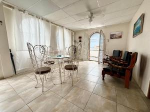 a dining room with a table and chairs and a piano at Las Casitas - Playas in Playas