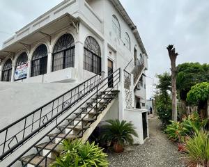 a white building with stairs in front of it at Las Casitas - Playas in Playas