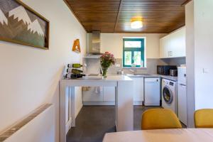 a kitchen with a white table and yellow chairs at Cozy cottage Geltschberg Nr. 1 in Liběšice