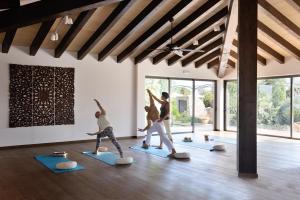 a group of people doing yoga in a room at Cal Reiet Holistic Retreat in Santanyi