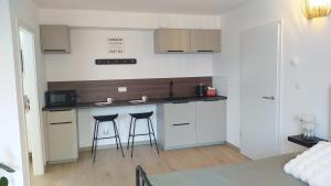 a kitchen with two bar stools in a room at Bois de rose in Theux