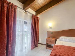 a bedroom with a bed and a window with red curtains at Vald Hotel in Val Della Torre +90 photos
