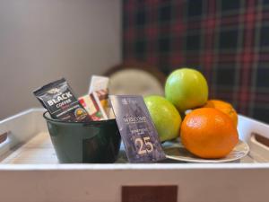a tray of fruit on a table with a bowl of apples and oranges at Apartment25 Poljice Apart Hotel Jahorina in Jahorina +7 photos
