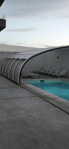 a building with a swimming pool with chairs at Quequen - Vista al Mar in Quequén