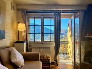 a living room with a couch and a large window at Trilocale a due passi dalle piste con balcone in Prato Nevoso +30 photos