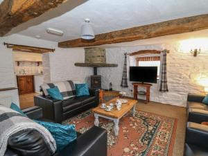 a living room with a couch and a table at Y Beudy in Llanybydder