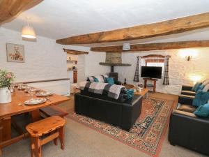 a living room with a couch and a table at Y Beudy in Llanybydder