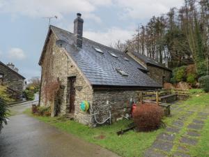 an old stone building with a black roof at Y Beudy in Llanybydder