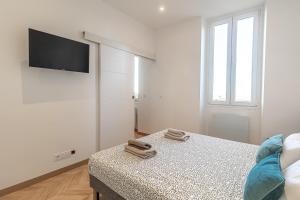 Dieses weiße Zimmer verfügt über ein Bett und einen Flachbild-TV. in der Unterkunft T2 Town Center, Casino in Beausoleil + 2 Fotos