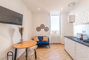 eine Küche mit einem Tisch und einem blauen Sofa in der Unterkunft T2 Town Center, Casino in Beausoleil