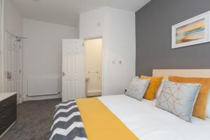 a bedroom with a bed with yellow and orange pillows at Crewe Rooms Brooklyn Street in Crewe