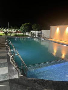 a large swimming pool at night with sidx sidx sidx sidx at luxurious farmhouse VILLA GRAND in Venkatāpur