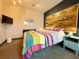 a bedroom with a bed and a wooden wall at Cod in Seahouses