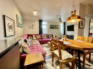 a living room with a pink couch and a table at Cod in Seahouses +7 photos