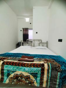 a bed with a blanket on top of it at Shivay Guest house in Jasidih
