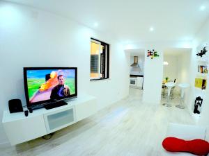 a living room with a flat screen tv on a white wall at Sao Paulo Apartment in Lisbon