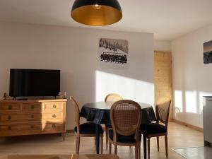 a dining room with a table and chairs and a television at Perle de Savoie B102 in Châtel