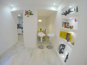 a white room with a table and a stool at Sao Paulo Apartment in Lisbon