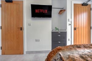 a bedroom with two doors and a television on the wall at Cozy bungalow near Concorde museum w/ backyard in Bristol +8 photos