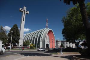 una cruz grande y una iglesia con un gran edificio en Gran Hotel Isabel Riquelme, en Chillán