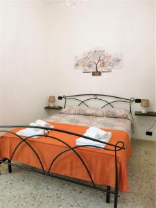 a bedroom with a bed with an orange blanket at La Taverna 98 in Otranto