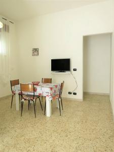 a dining room with a table and chairs and a television at La Taverna 98 in Otranto