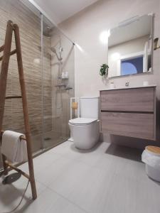 a bathroom with a toilet and a glass shower at Apartamento María Platero Céntrico y con las mejores vistas del casco antiguo la montaña y el mar mediterráneo in Frigiliana