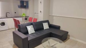 a living room with a black couch and a glass table at El Encanto Andaluz 1 in Córdoba