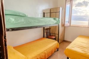 two bunk beds in a room with a window at Casa Mare Torre San Carlo in Marina di Palma