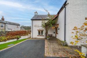 a white house with a driveway in front of it at Margaret House - Pooley Bridge, Ullswater in Pooley Bridge