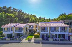 een rij huizen aan het water bij Elpiniki Luxury Apartments in Nea Potidaea