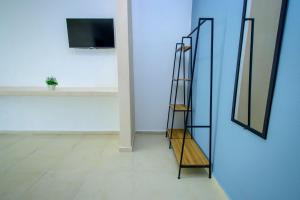 a shelf in a room with a tv on a wall at Hotel Paso del Mar Playa del Carmen in Playa del Carmen +23 photos