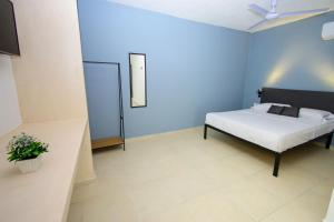a bedroom with a bed and a blue wall at Hotel Paso del Mar Playa del Carmen in Playa del Carmen