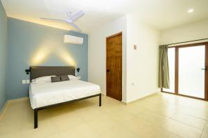 a bedroom with a bed and a ceiling fan at Hotel Paso del Mar Playa del Carmen in Playa del Carmen