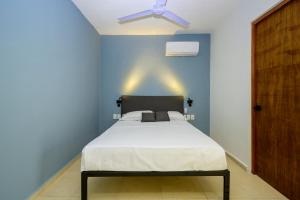 a bedroom with a bed with a ceiling fan at Hotel Paso del Mar Playa del Carmen in Playa del Carmen