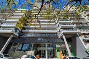 a tall building with cars parked in front of it at La Vie Suite Barrio Norte in Buenos Aires