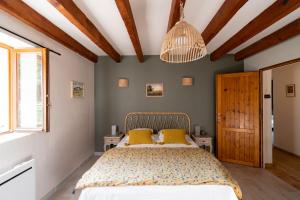 a bedroom with a bed with yellow pillows at Les Prés d'Allerey in Allerey-sur-Saone