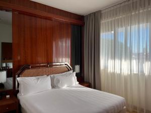 łóżko w pokoju hotelowym z oknem w obiekcie Hotel Napoleon w Lukce +37 zdjęć